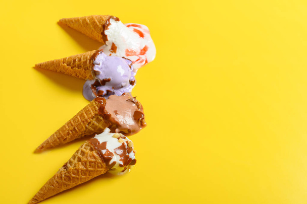 múltiples conos de helado de sabor en un proceso de fusión sobre fondo amarillo con espacio de copia
 - Foto, imagen