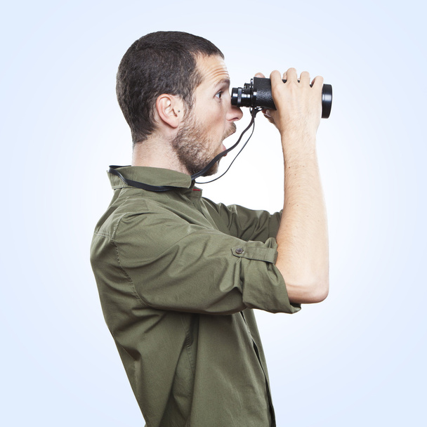 young man looking through binoculars, surprise face expression - 写真・画像