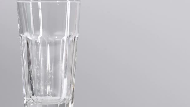 Bolhas de água em vidro movendo-se para cima. Vidro de água isolado em fundo branco com pequenas bolhas
. - Filmagem, Vídeo