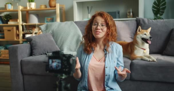 Happy woman recording video about dogs at home using professional camera - Materiał filmowy, wideo