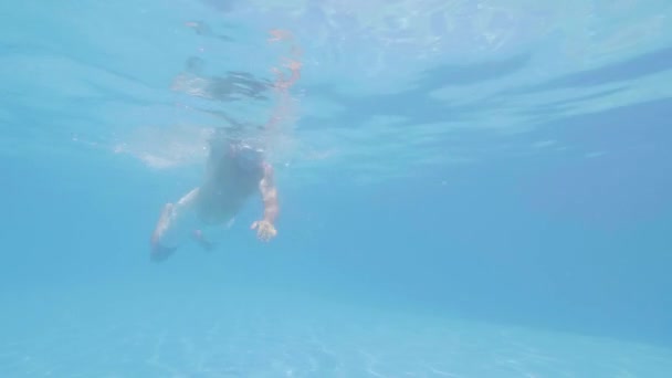 Iäkäs mies suojalasit on uinti freestyle altaassa
. - Materiaali, video
