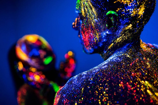 people are colored fluorescent powder. a pair of lovers dancing at a disco - Zdjęcie, obraz