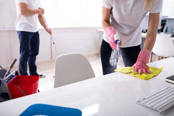 Two Janitor Cleaning The Desk And Mopping Floor In The Office - Фото, зображення