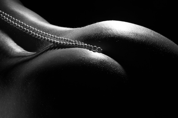 Beautiful naked female body on a dark background - Foto, Imagem