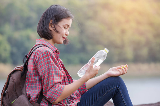 Жінка туристка з рюкзаком питної води в природі
 - Фото, зображення