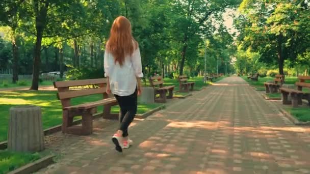 femme aux cheveux roux se tournent vers la caméra flâner dans la ville de printemps
 - Séquence, vidéo