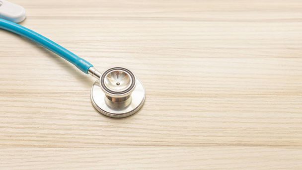 De blauwe stethoscopen op houten tafel voor medische inhoud. - Foto, afbeelding
