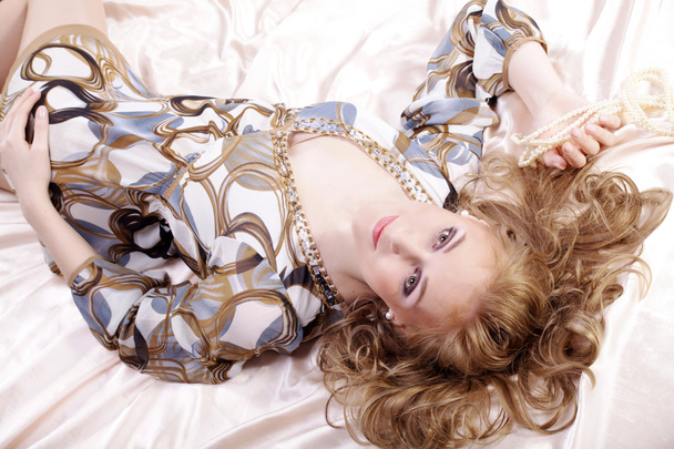 Blonde girl in underwear lying on a bed - Foto, imagen