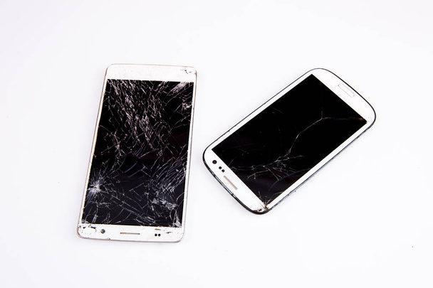 Mobiles Smartphone mit kaputtem Bildschirm isoliert auf weiß. - Foto, Bild