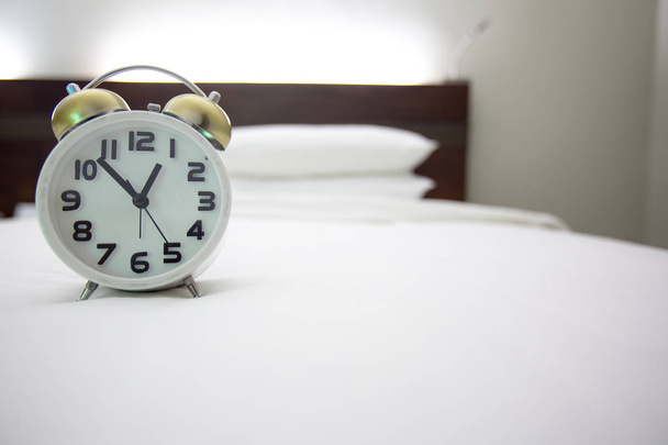 белый будильник и кровать
 - Фото, изображение