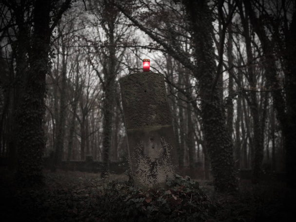 Halloween sírkő gyertyával a háttérben - Fotó, kép