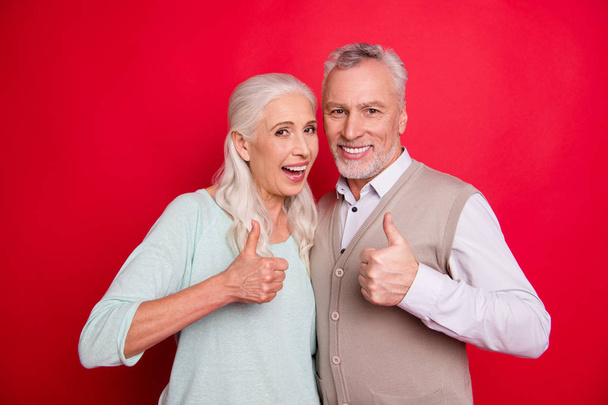 Close up photo amazing funny she her he him his old guy lady hugging best partners thumbs up symbol amazed advising buy buyer product wear sweater pullover shirt waistcoat isolated red background - Foto, imagen
