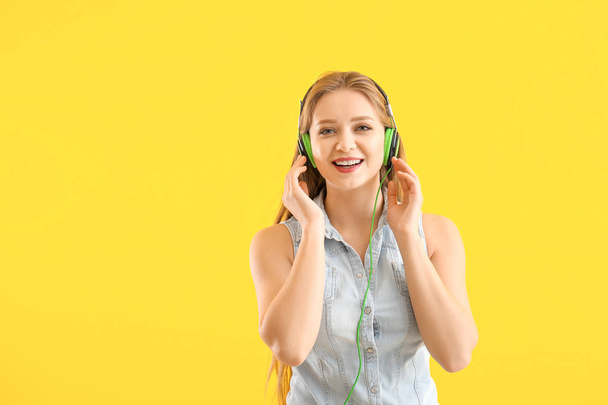 Beautiful young woman listening to music against color background - Zdjęcie, obraz