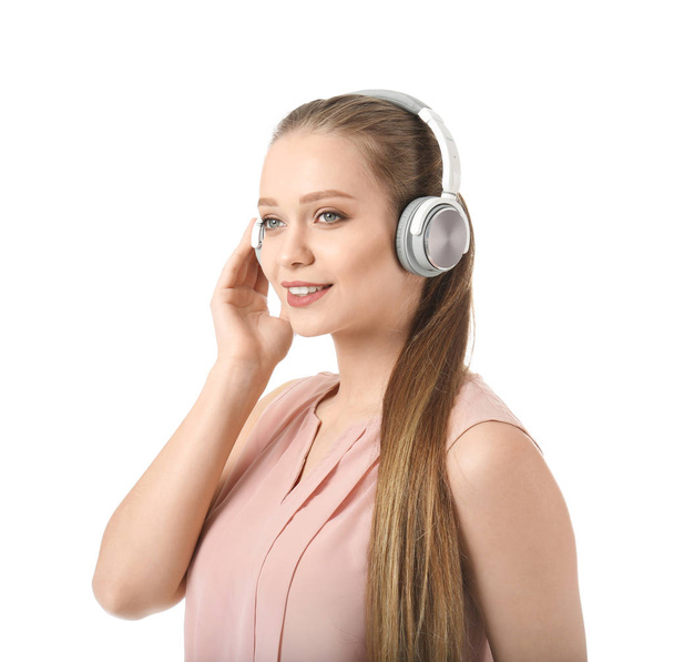 Красивая молодая женщина слушает музыку на белом фоне - Фото, изображение
