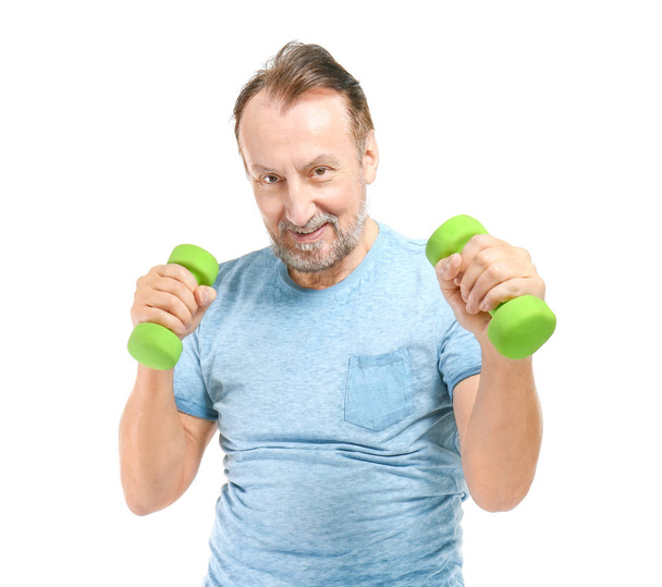 Portrait of handsome mature man with dumbbells on white background - Photo, Image