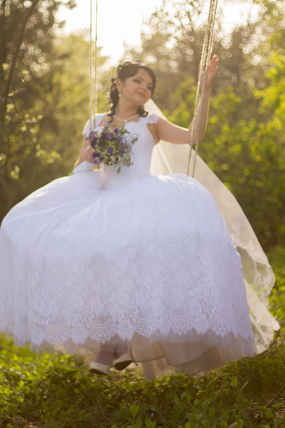 Portrait of a beautiful bride in white wedding dress sitting on - Foto, Bild