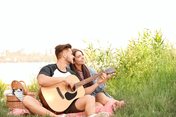 Jeune couple avec guitare sur pique-nique dans le parc
 - Photo, image
