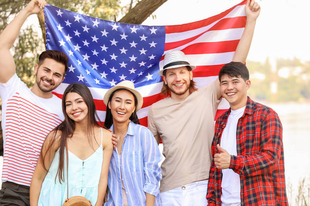 Young people with USA flag outdoors. Independence Day celebration - Photo, Image
