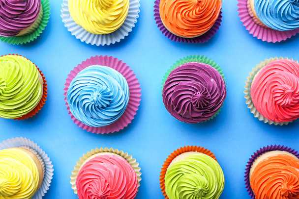 Zoete smakelijke cupcakes op kleur achtergrond - Foto, afbeelding