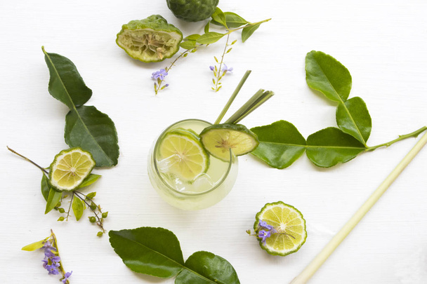 pflanzliche gesunde Getränke Eiskaffir-Limetten-Cocktail-Wasser mit Bergamottenscheiben lokale Flora Asiens Anordnung flach liegend auf weißem Hintergrund - Foto, Bild