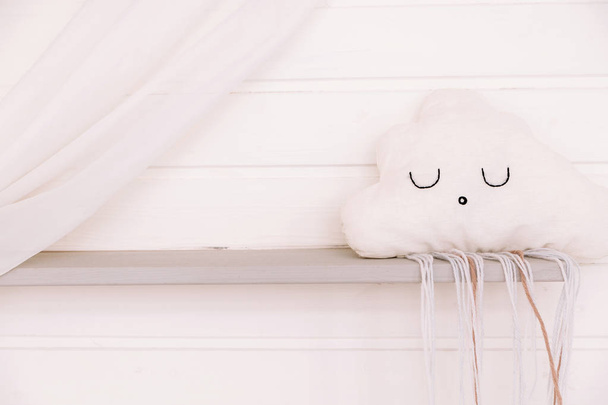 木製の壁を背景に雲の形をした子供枕 - 写真・画像