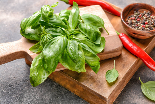 Wooden boards with fresh basil, chili peppers and spices on grey background - 写真・画像