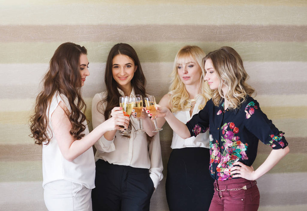 Meisjes feliciteren vriend op haar verjaardag met glazen champagne in de hand. - Foto, afbeelding
