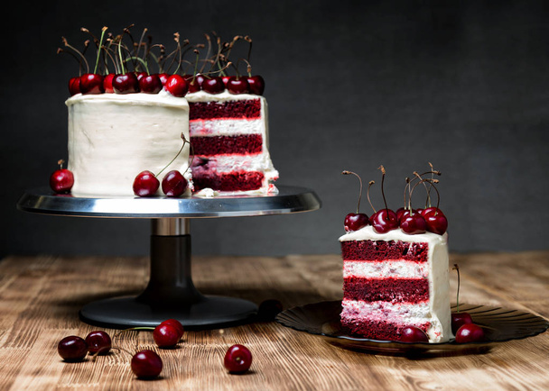 Kek "Kırmızı kadife", çok güzel, tatlı bir kiraz ile, koyu bir arka plan ve açık ahşap masa - Fotoğraf, Görsel