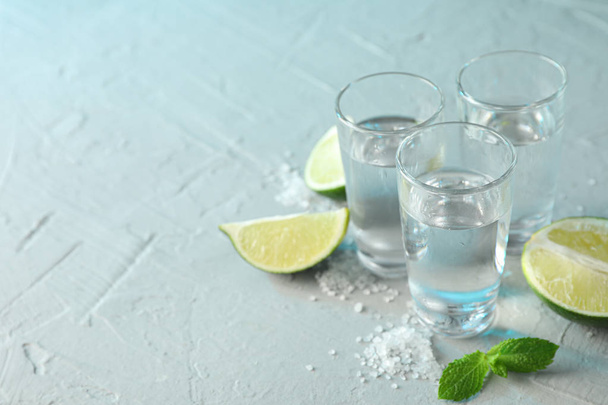 Tequila képek, só, lime szelet és a menta a fehér cement háttérben - Fotó, kép