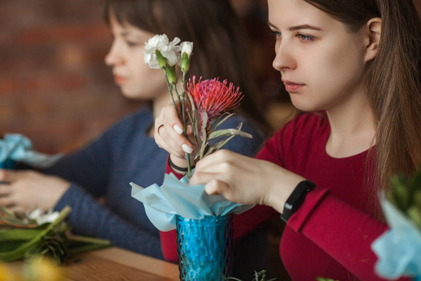 Floral maser-class. Women making a floral composition with fresh flowers. - Photo, Image