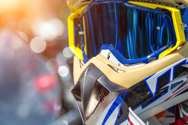 Moto helmet with on motorcycle handlebars and motorbikes on blur - 写真・画像