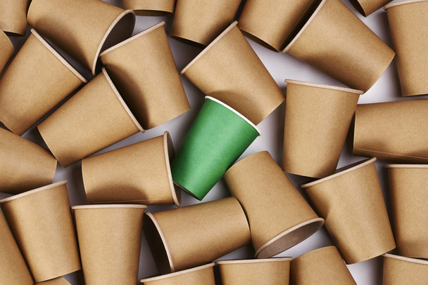 Caneca descartável verde entre canecas de papel
  - Foto, Imagem