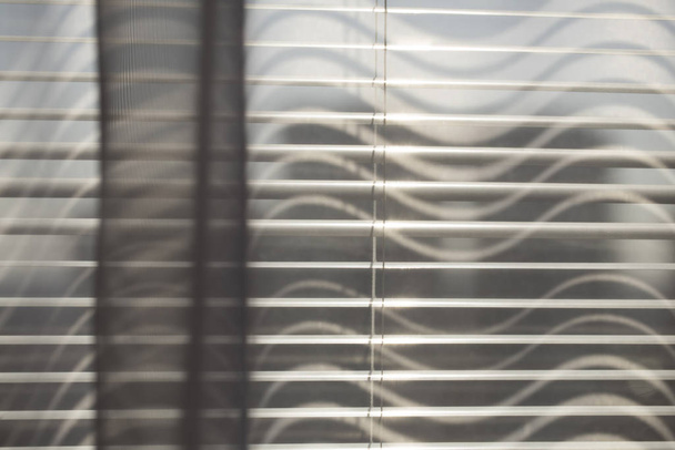Cortinas transparentes cinza na janela jalousie
.   - Foto, Imagem