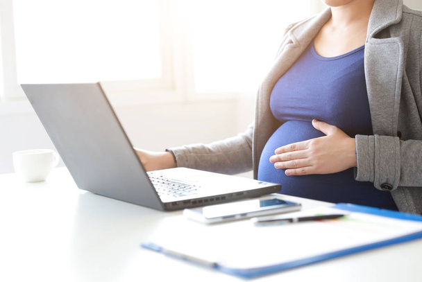 donna incinta sta lavorando su computer portatile e telefono cellulare, affari - Foto, immagini