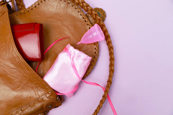 Copa menstrual en un bolso, estilo de vida. El concepto de salud de la mujer, eco y vida sin desperdicio
 - Foto, imagen
