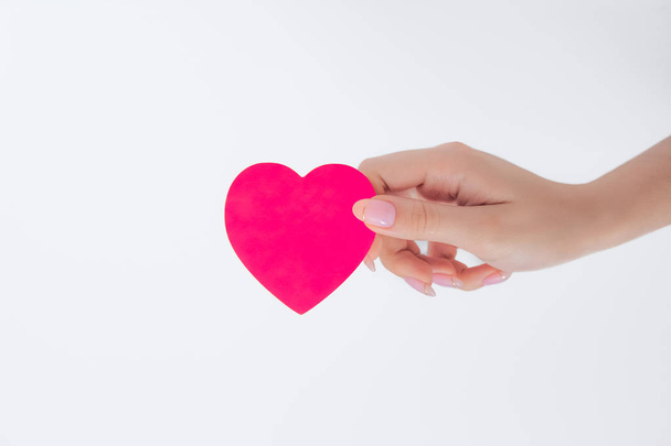 female hand holding red pink heart shape card isolated on white background - Photo, image