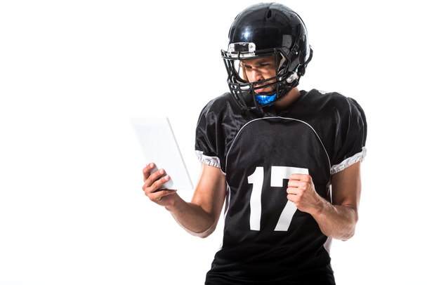 Jugador de fútbol americano en casco con tableta digital y mano apretada aislada en blanco
 - Foto, imagen