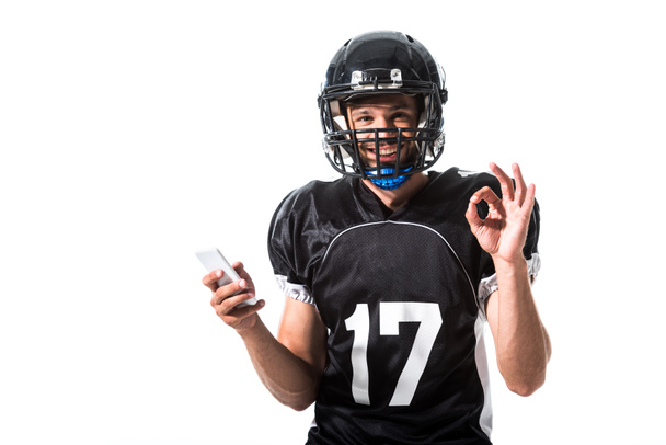 Американский футболист со смартфоном и табличкой "Изолированный на белом"
 - Фото, изображение