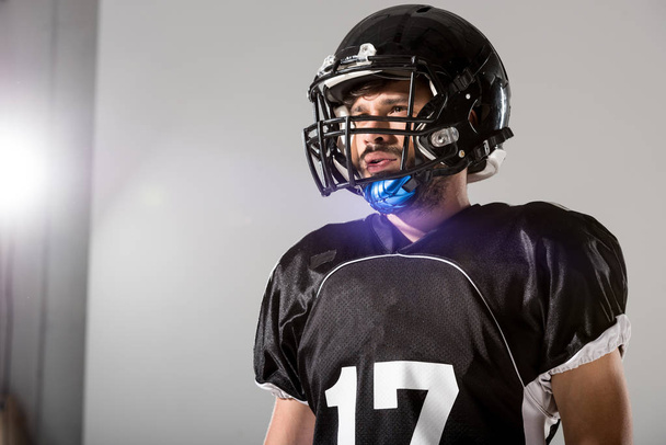 Giocatore di football americano in casco grigio con retroilluminazione e spazio copia
 - Foto, immagini