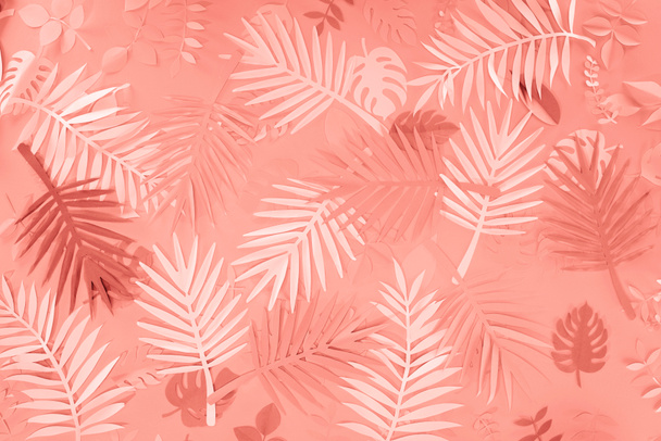 top view of coral tropical paper cut palm leaves, minimalistic background - Fotó, kép
