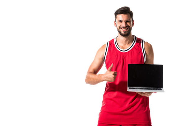 basketball player showing thumb up and holding laptop Isolated On White  - Фото, изображение
