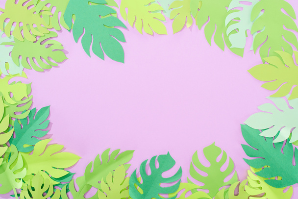 top view of green paper cut tropical leaves on violet background with copy space - Zdjęcie, obraz