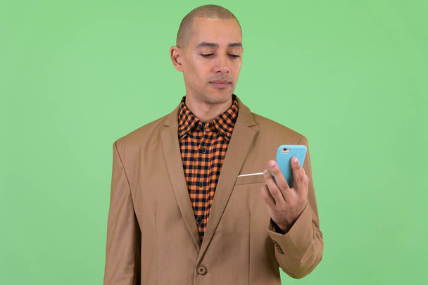 Handsome bald multi ethnic businessman using phone - Foto, Imagen