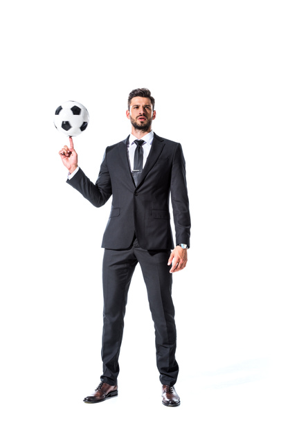 handsome businessman in formal wear spinning soccer ball on finger Isolated On White - 写真・画像