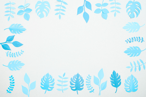 top view of blue paper cut tropical leaves isolated on white with copy space - Zdjęcie, obraz