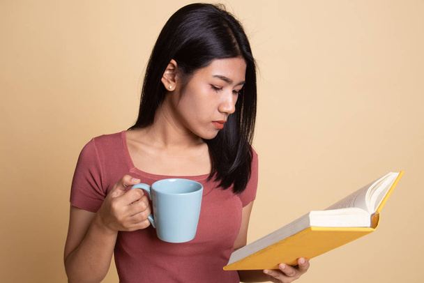 Young Asian woman with a book and cup of coffee. - Photo, image