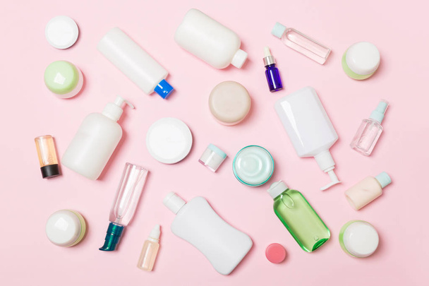 Group of plastic bodycare bottle Flat lay composition with cosmetic products on pink background empty space for you design. Set of White Cosmetic containers, top view with copy space - Photo, Image