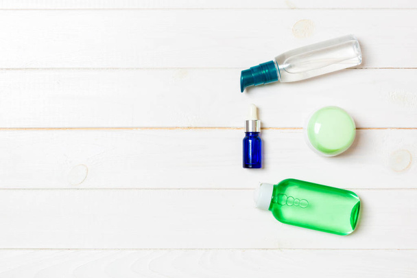Maqueta de marca Cosmetics SPA, vista superior con espacio para copiar. conjunto de tubos y frascos de crema plana sobre fondo de madera blanca
 - Foto, imagen