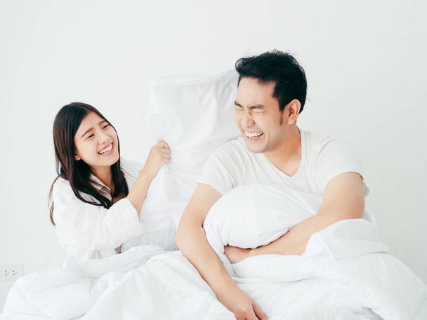 Happy Asian couple playing pillow on bed, lover lifestyle concep - Fotoğraf, Görsel