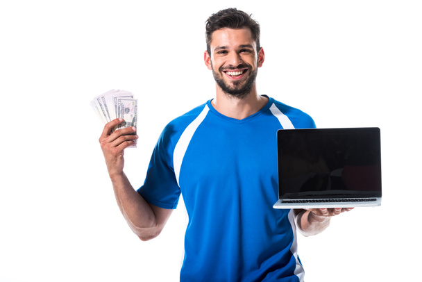dizüstü bilgisayar ve dolar banknotlar ile mutlu futbol oyuncusu beyaz üzerinde Izole - Fotoğraf, Görsel